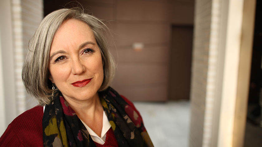 Woman with grey hair in office corridor